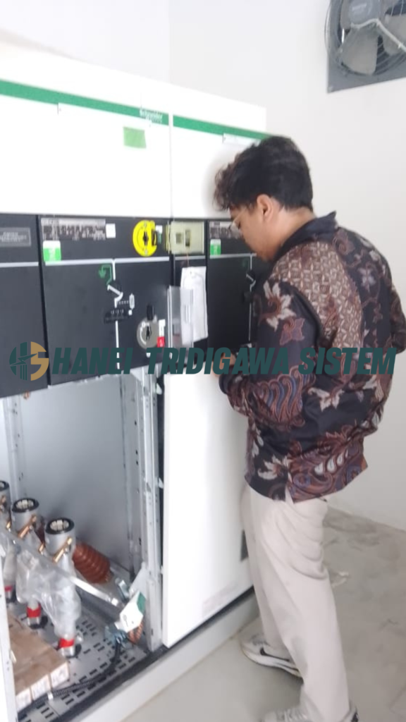 Teknisi memeriksa panel listrik Schneider Electric – Hanei Tridigawa Sistem