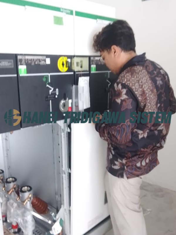 Teknisi memeriksa panel listrik Schneider Electric – Hanei Tridigawa Sistem